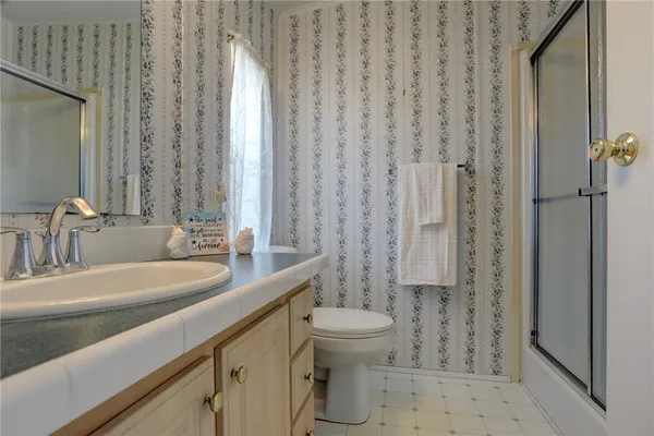 a bathroom with a sink a toilet and shower