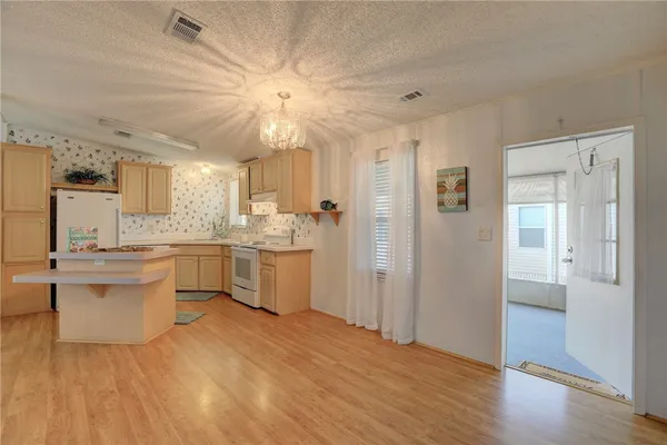 a kitchen with a refrigerator and white cabinets