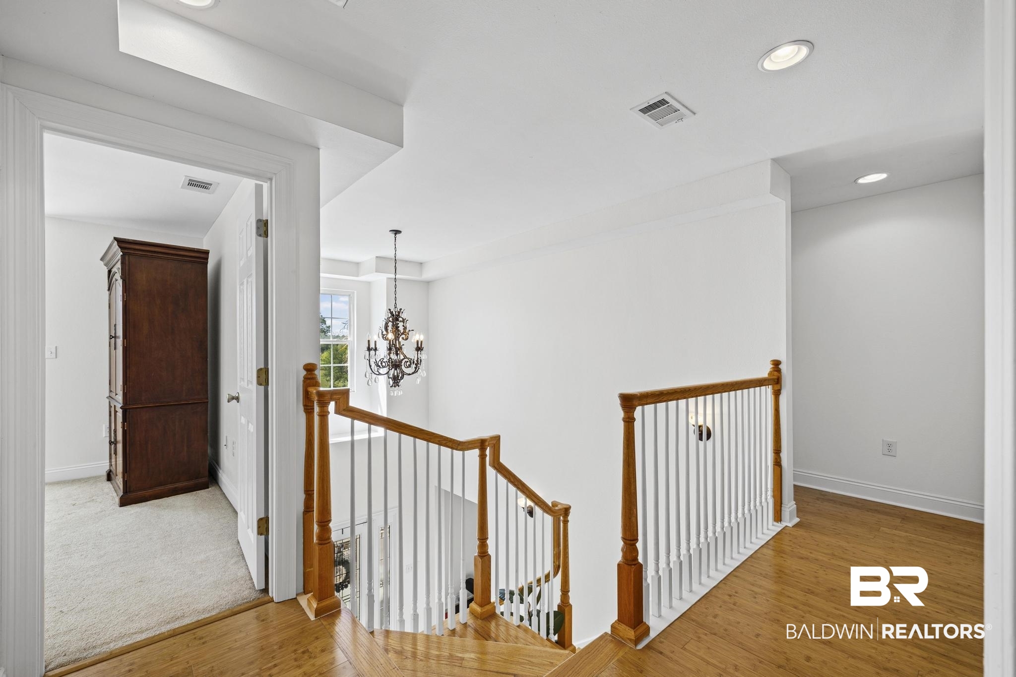 32875 Faircloth Road Lillian, AL 36549 - Photo 40 of 85 Hallway with an upstairs landing, a chandelier, and light wood finished floors