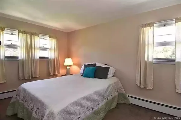 a bedroom with a bed and a flat tv screen on the dresser