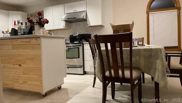 a kitchen with a table chairs refrigerator and cabinets