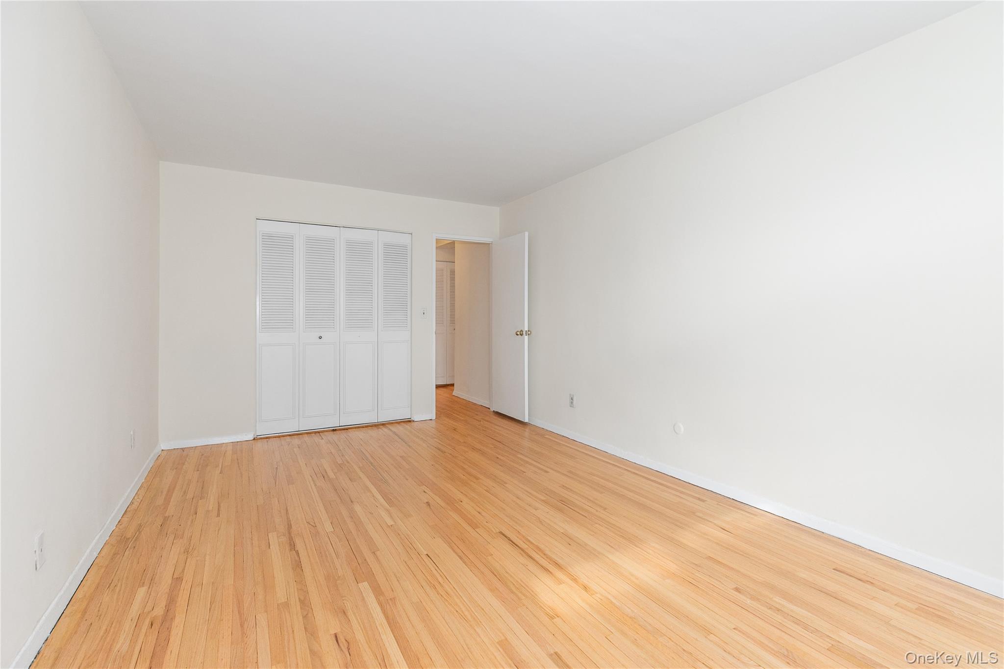 25 Park Place, Unit 2G Great Neck, NY 11021 - Photo 14 of 20 a view of empty room with wooden floor