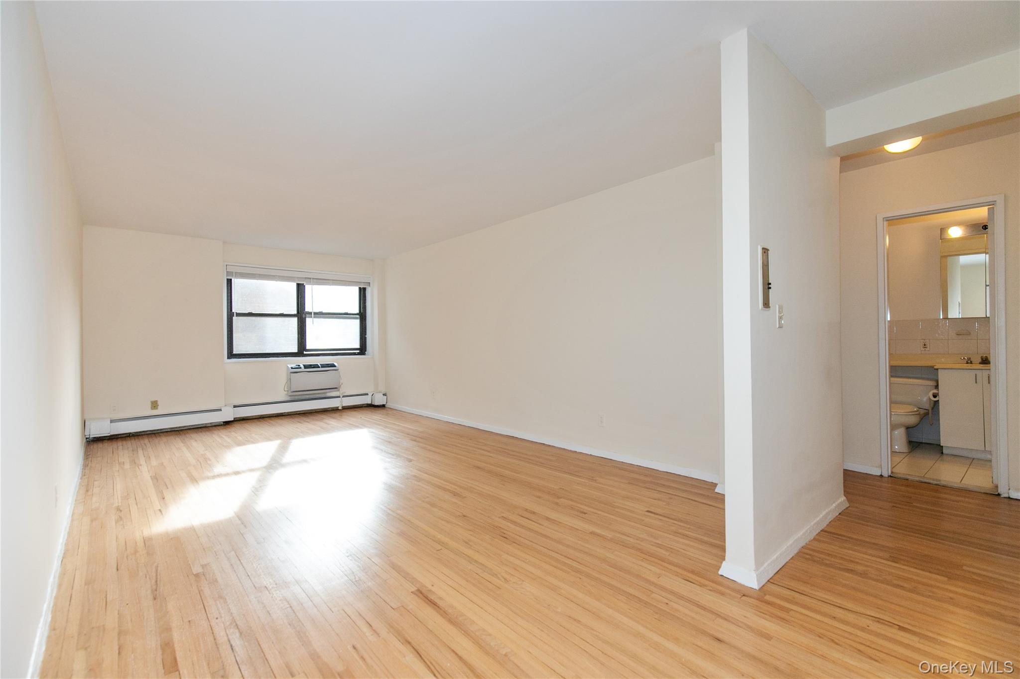 25 Park Place, Unit 2G Great Neck, NY 11021 - Photo 4 of 20 a view of empty room with wooden floor and fan