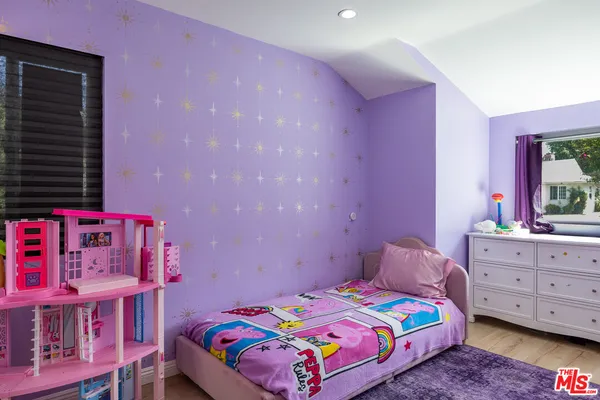 a bedroom with bed and a baby crib