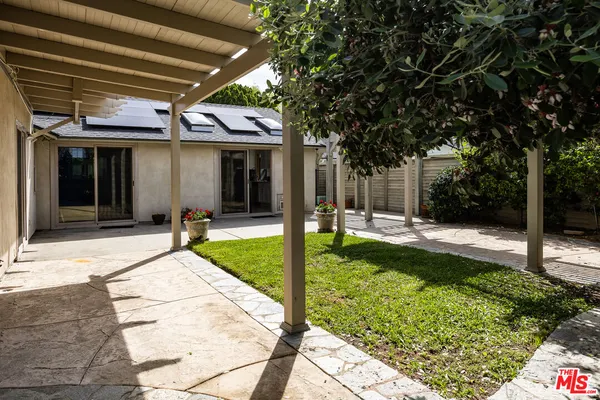 a view of a patio with table and chairs potted plants and palm tree