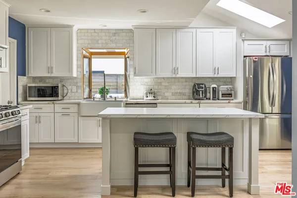 a kitchen with stainless steel appliances a stove a sink refrigerator and a refrigerator