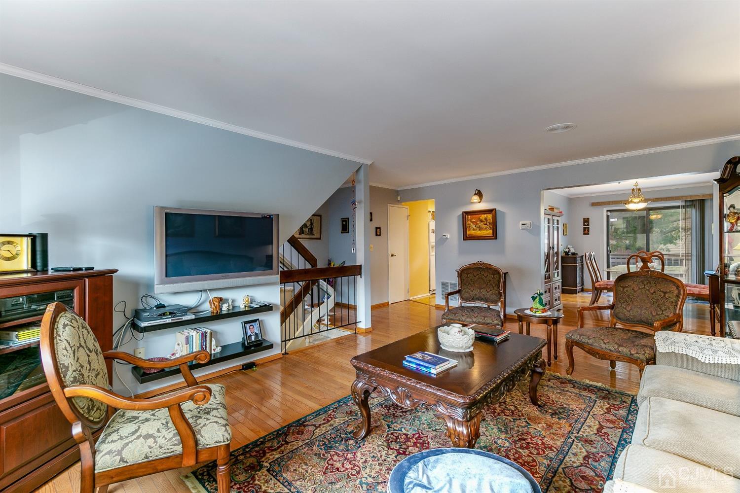 7303 Hana Road Edison, NJ 08817 - Photo 10 of 24 a living room with furniture a flat screen tv and a table