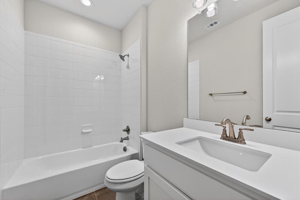 4123 Windy Point Court Oak Point, TX 75068 - Photo 25 of 29 Bathroom featuring a spacious white vanity with an integrated rectangular sink, brushed nickel faucet, large wall mirror, and a white tile shower-tub combination