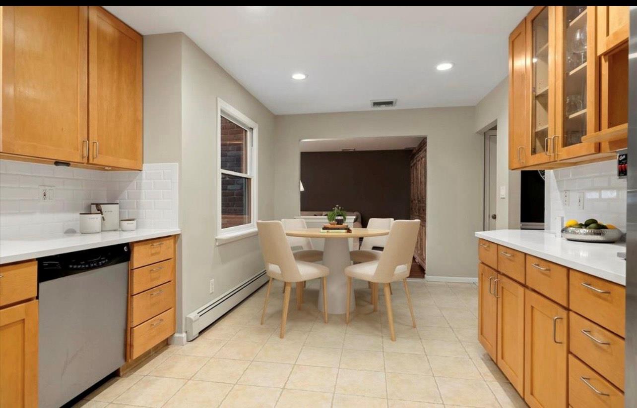 240 Plainview Road Woodbury, NY 11797 - Photo 4 of 22 a kitchen with a sink and chairs