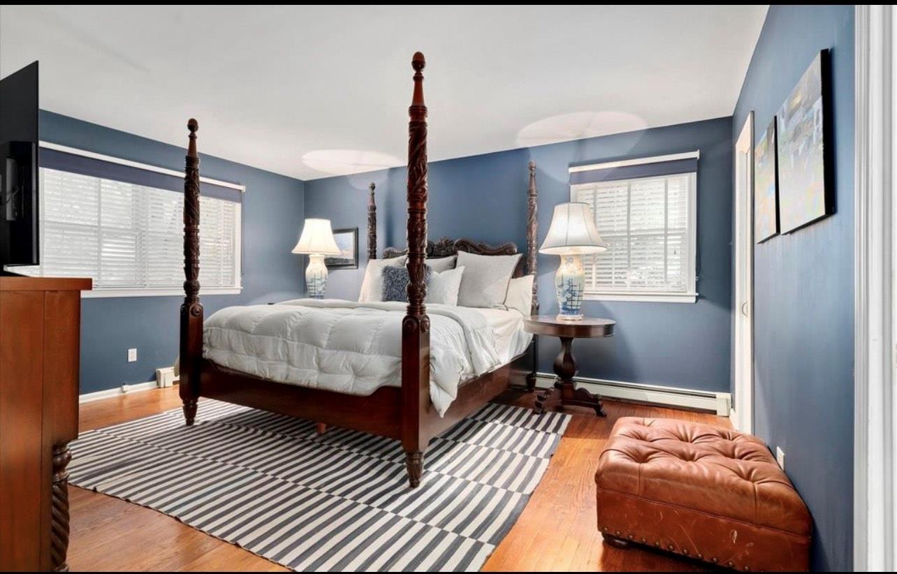 240 Plainview Road Woodbury, NY 11797 - Photo 8 of 22 a bedroom with a bed wooden floor and window