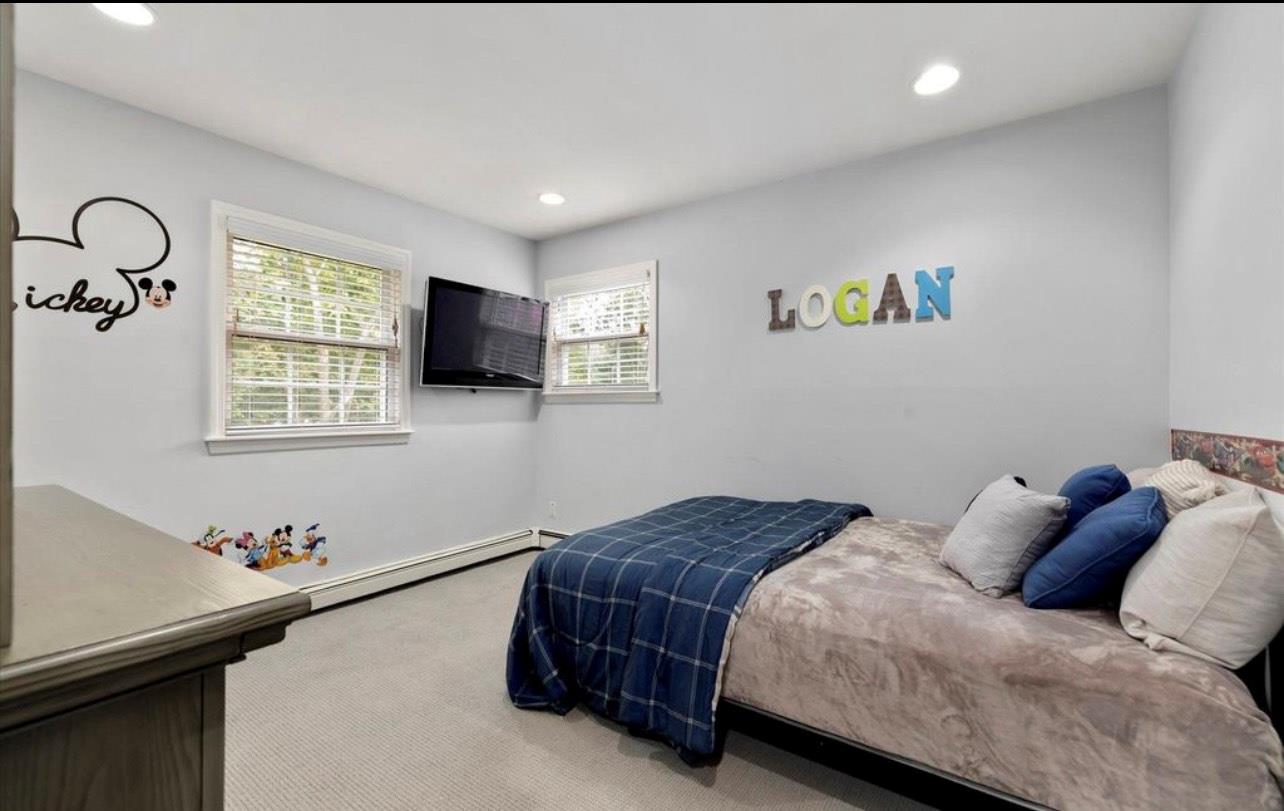 240 Plainview Road Woodbury, NY 11797 - Photo 9 of 22 a bedroom with a bed and a flat screen tv