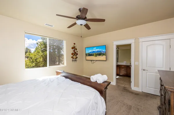 a bedroom with a large bed and a chandelier