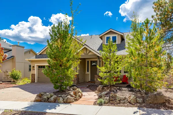 a front view of a house with a yard and potted plants
