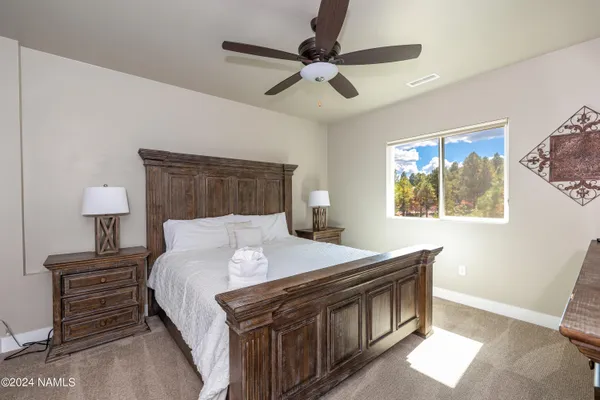 a bedroom with a bed and a lamp on the dresser
