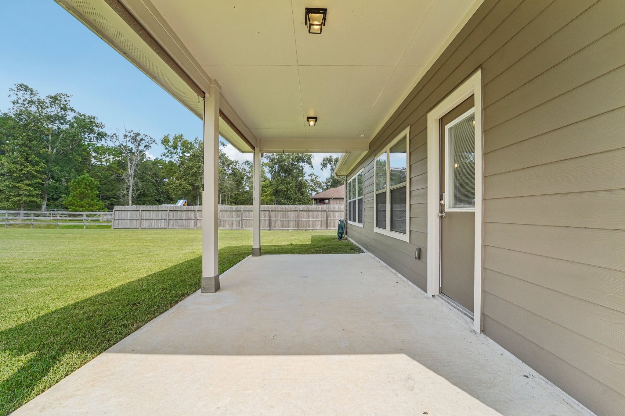 4542 Coues Deer Lane Conroe, TX 77303 - Photo 41 of 50 Spacious covered patio overlooking a lush backyard—perfect for outdoor gatherings and relaxation.