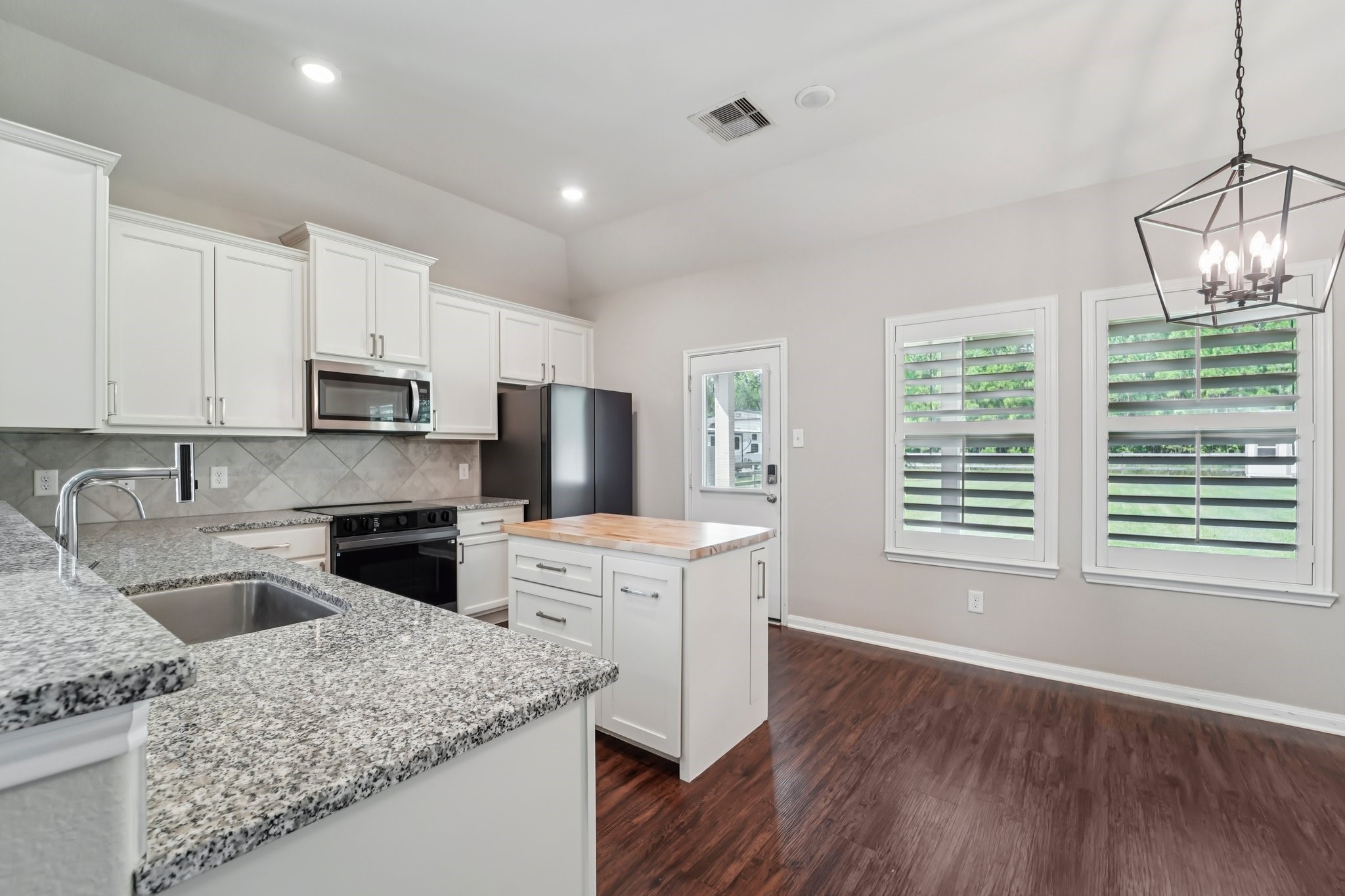 4542 Coues Deer Lane Conroe, TX 77303 - Photo 9 of 50 Modern kitchen featuring elegant granite countertops and a chic island for added functionality.