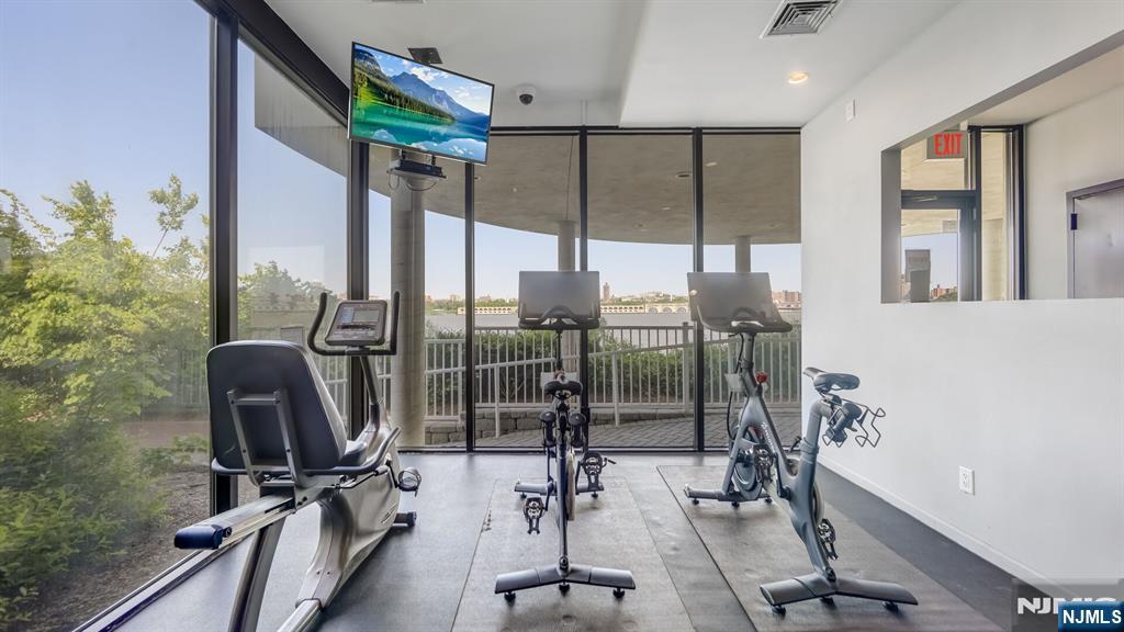 1077 River Road, Unit TH5 Edgewater, NJ 07020 - Photo 18 of 22 a room with gym equipment and a floor to ceiling window
