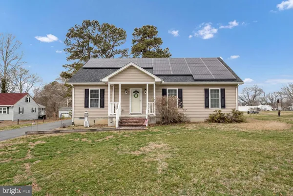 a front view of a house with a garden and trees