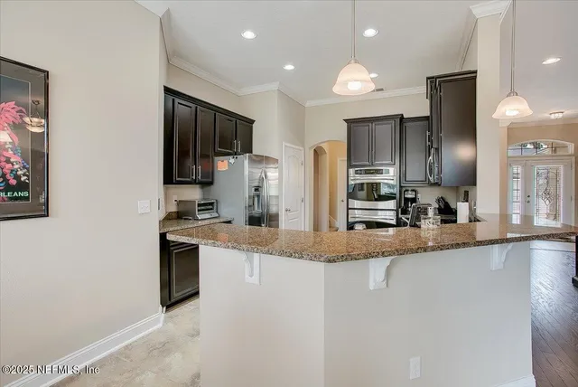 a large kitchen with granite countertop a sink counter top space appliances and cabinets