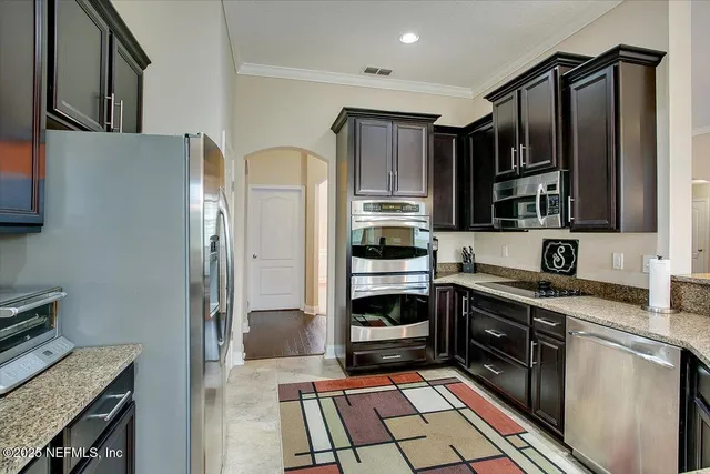 a kitchen with stainless steel appliances granite countertop a refrigerator stove and sink