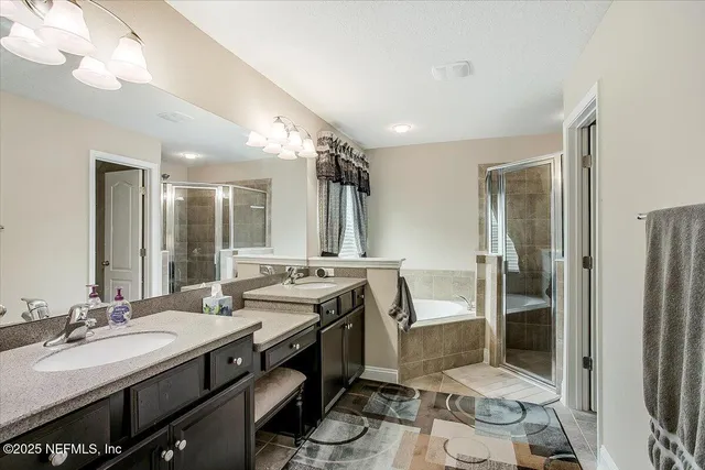 a bathroom with a double vanity sink a mirror and a shower
