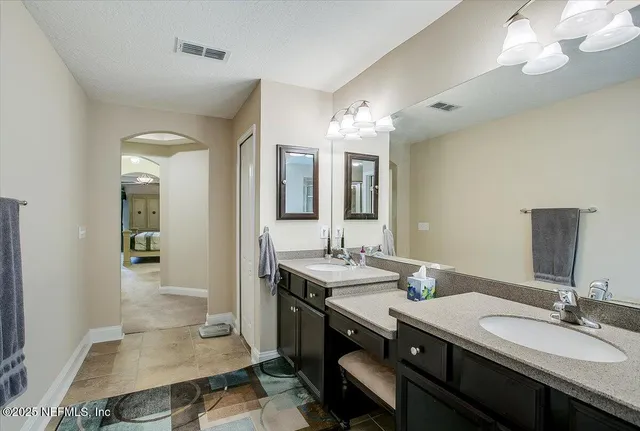 a en suite bathroom with a double vanity sink and a mirror