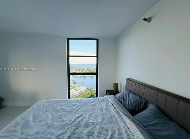 a view of a livingroom with furniture and floor to ceiling window