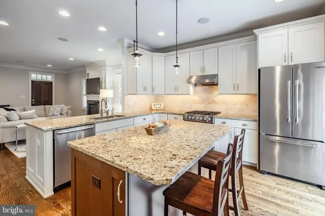 a large kitchen with granite countertop a sink stainless steel appliances and cabinets