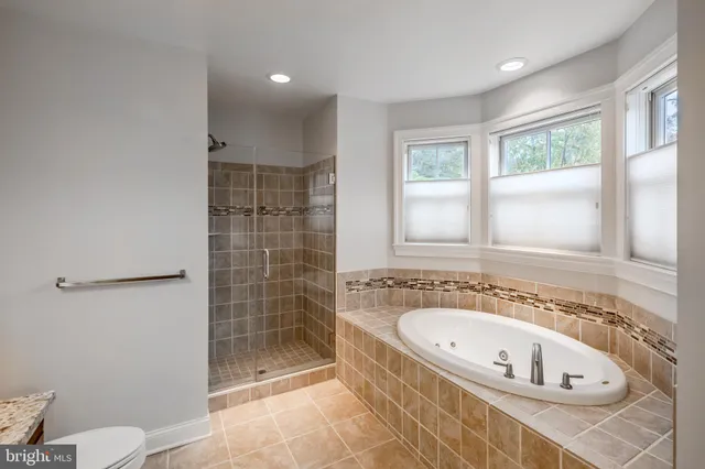 a bathroom with a granite countertop sink a toilet a mirror and shower