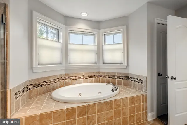 a view of an empty room with wooden floor and windows