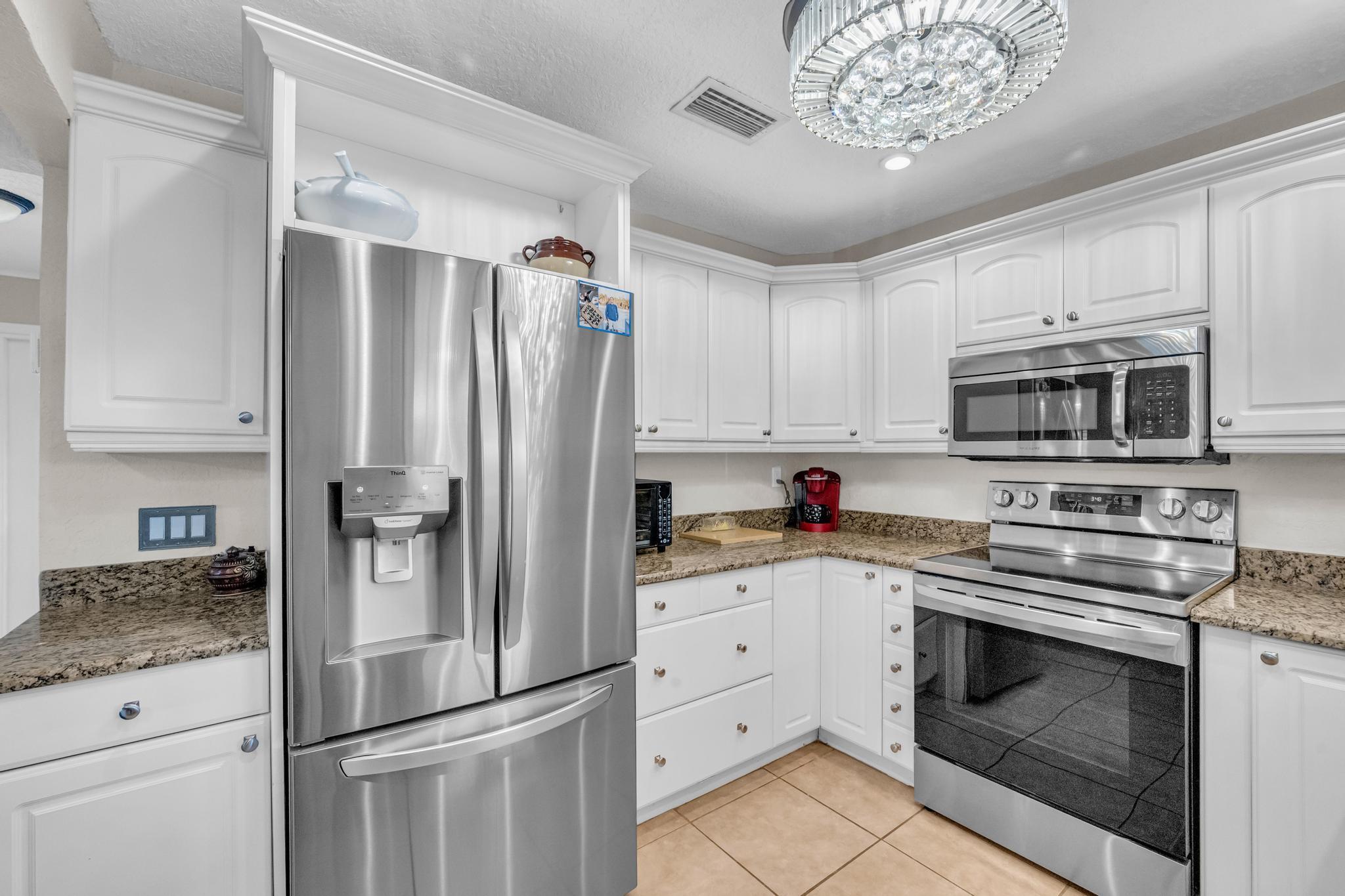 4167 Russell Street Jupiter, FL 33469 - Photo 11 of 60 a kitchen with stainless steel appliances white cabinets and a sink
