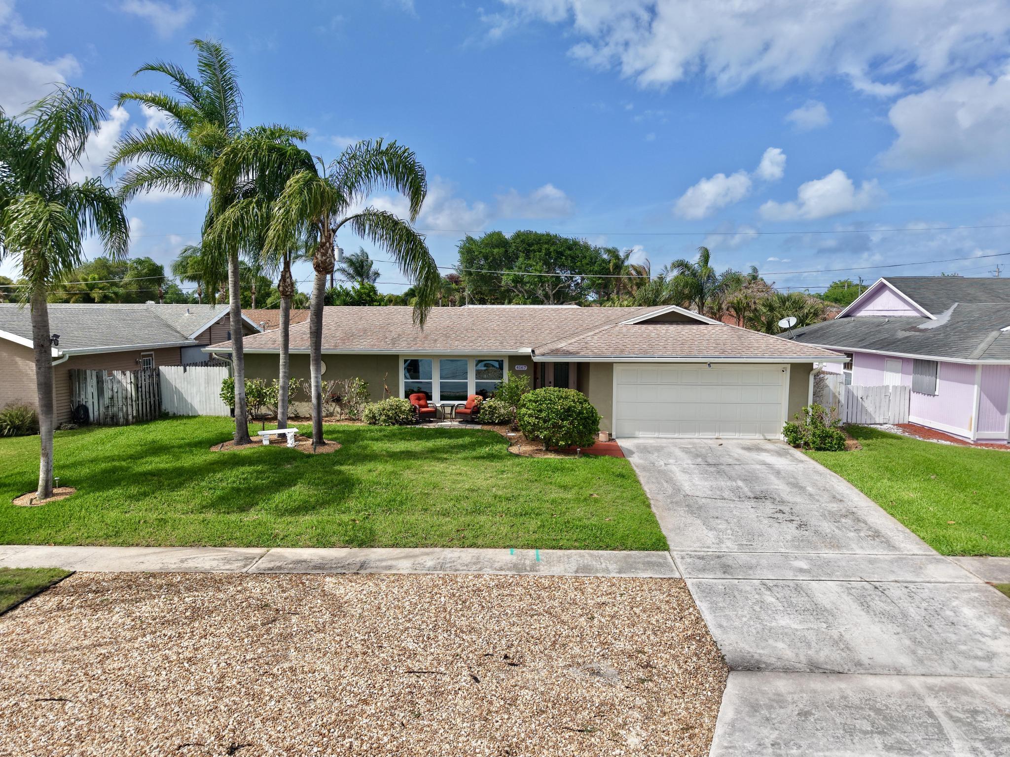 4167 Russell Street Jupiter, FL 33469 - Photo 2 of 62 a view of a front of house with a yard and potted plants