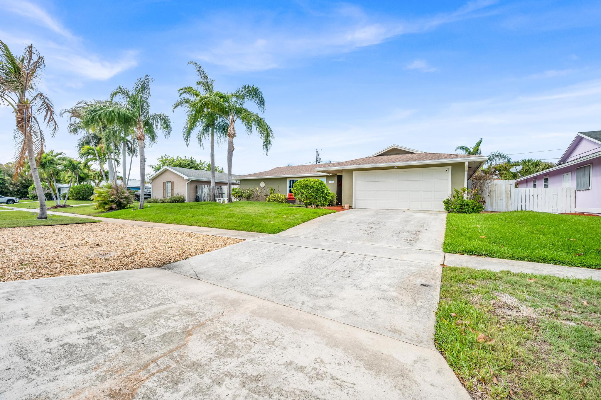 4167 Russell Street Jupiter, FL 33469 - Photo 57 of 60 a front view of house with yard and green space