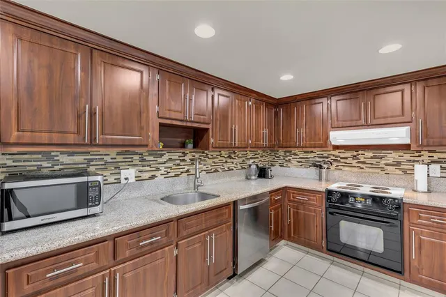 a kitchen with stainless steel appliances granite countertop a refrigerator sink and cabinets