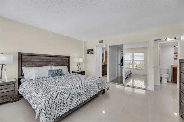 a bedroom with a large bed and a chandelier