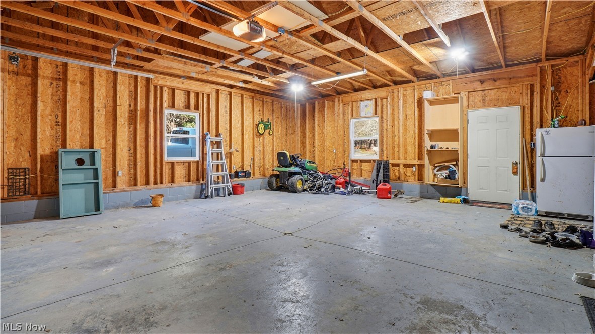 65892 Endley Road Cambridge, OH 43725 - Photo 44 of 50 Garage with freestanding refrigerator and a garage door opener