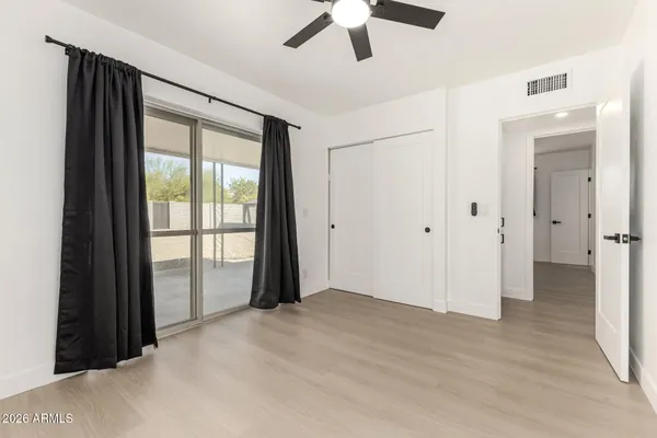 a view of a room with wooden floor and ceiling fan