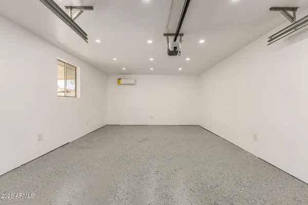 an empty room with a ceiling fan and windows
