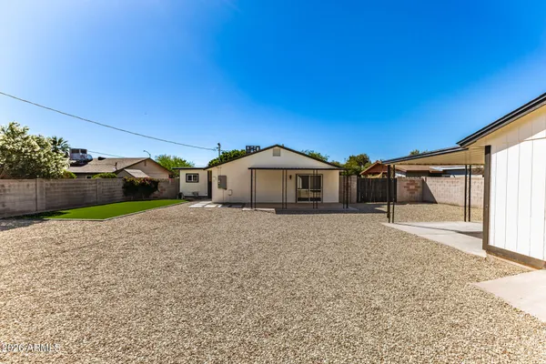 a view of a house with backyard and sitting area