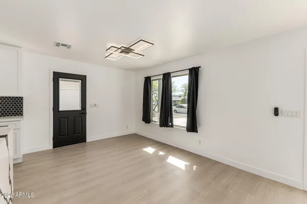 a view of a hallway with white walls and wooden floors