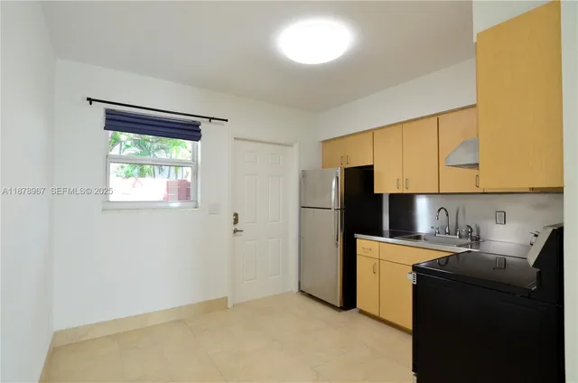a kitchen with a refrigerator sink and cabinets