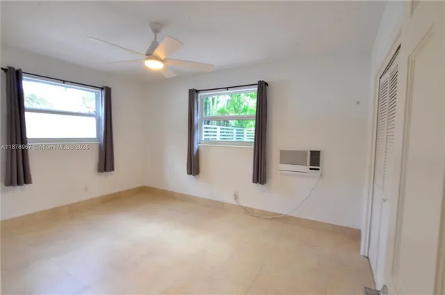 an empty room with windows and closet
