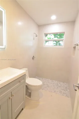 a bathroom with a sink a toilet and a window
