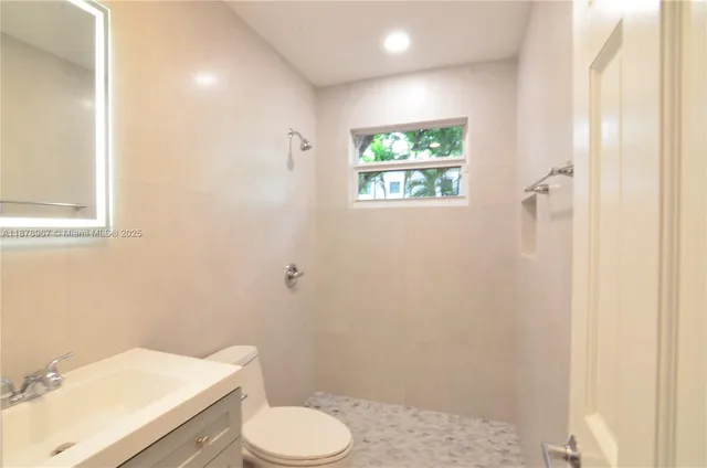 a white toilet sitting next to a bathroom sink