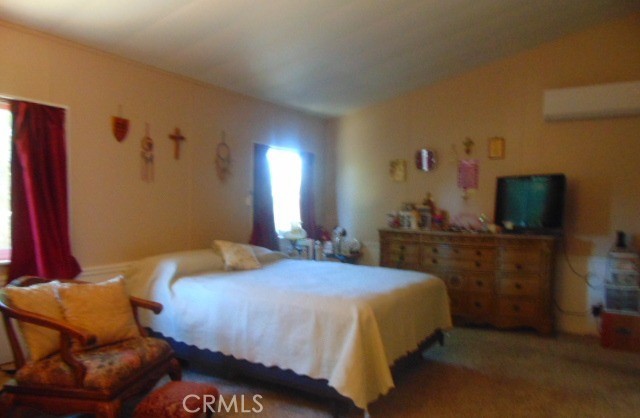 3835 Gardiner Ferry Road, Unit 36 Corning, CA 96021 - Photo 18 of 43 a bedroom with a bed and a flat tv screen on dresser