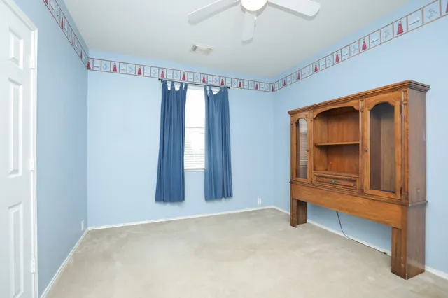 a view of an empty room with a fireplace and a window