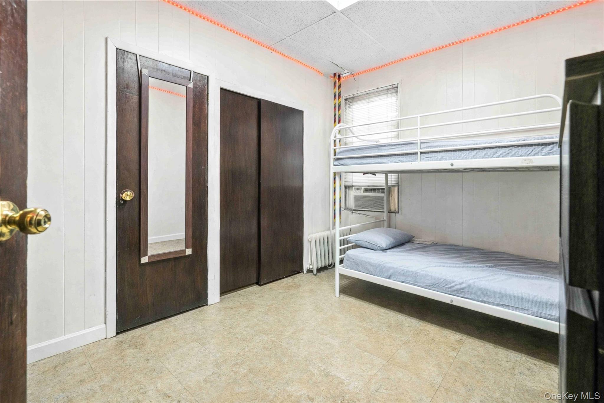 96-12 34th Avenue Queens, NY 11368 - Photo 16 of 35 a bedroom with a bed and cabinet