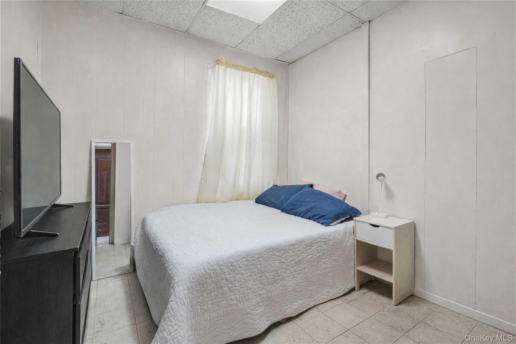 96-12 34th Avenue Queens, NY 11368 - Photo 18 of 35 a bedroom with a bed and a flat screen tv