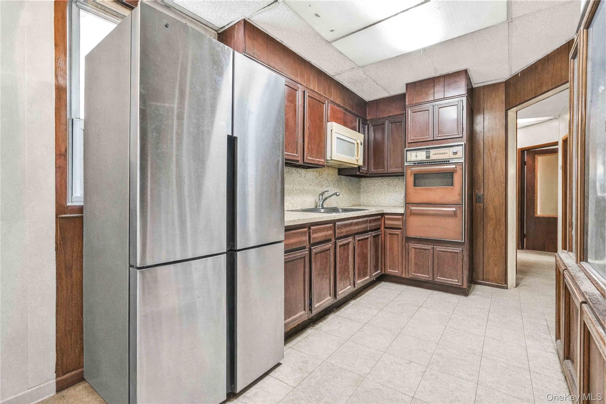 96-12 34th Avenue Queens, NY 11368 - Photo 21 of 35 a kitchen with stainless steel appliances a refrigerator and cabinets