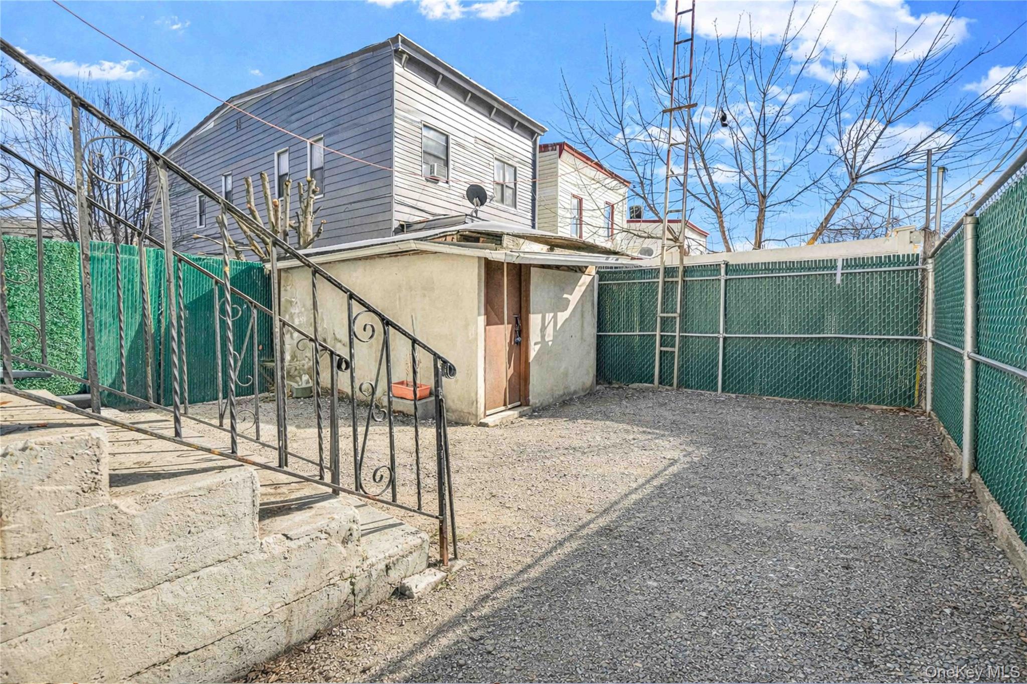 96-12 34th Avenue Queens, NY 11368 - Photo 29 of 35 a view of a house with a small yard and wooden fence